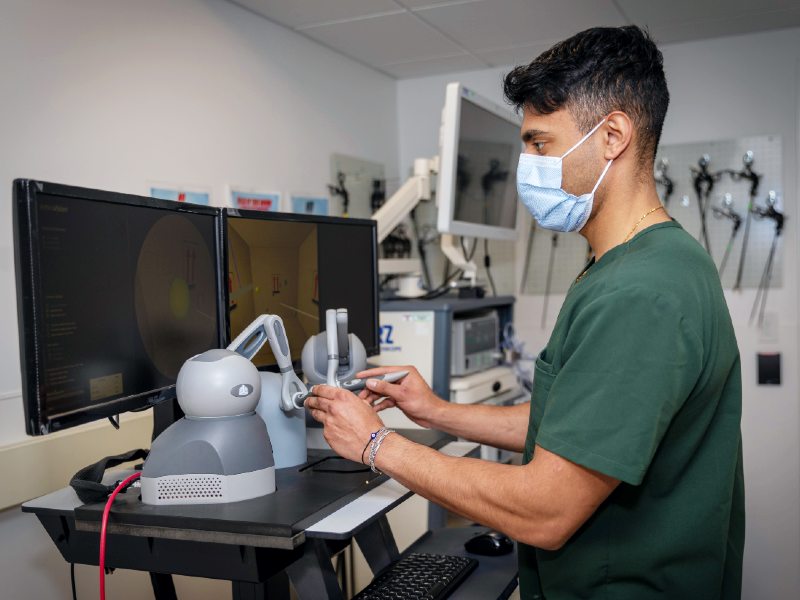 A student wearing a mask uses simulation tools